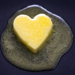 a heart shaped butter pat melting on a non-stick surface